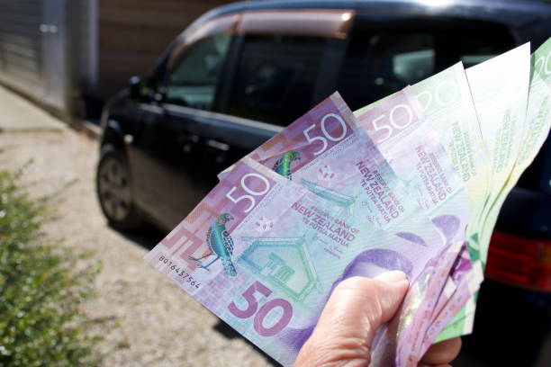 The Cost of a Car - NZD New Zealand Dollars The Cost of a Car Concept - NZD New Zealand Dollars with a Car in the Background out of Four. cash for cars stock pictures, royalty-free photos & images