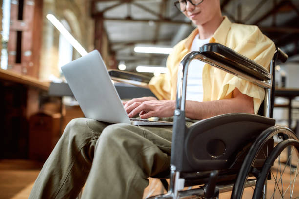 istock Everyone is needed. Guy in a wheelchair working in the office 1209751999