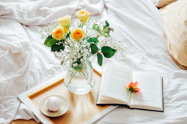 istock Lazy morning in bed. Flowers and tea for two. Easy reading on weekend. 1209754698