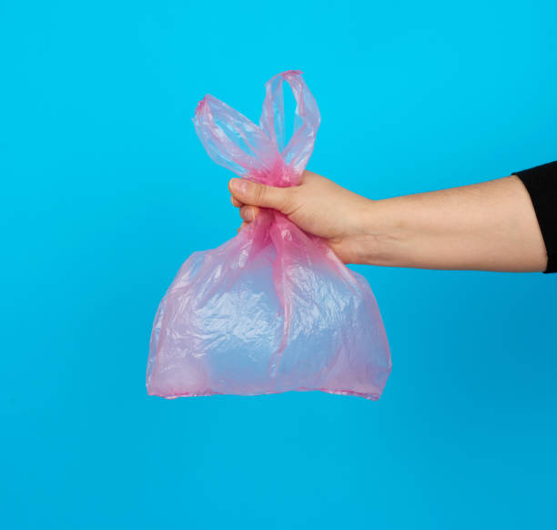 istock hand holds an empty pink plastic bag on a blue background 1209755479