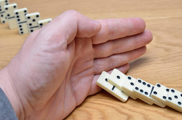 istock Domino effect, chain reaction is stopped by a human hand 1209761574