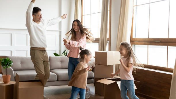 istock Overjoyed young parents dance with little kids moving in 1209762661