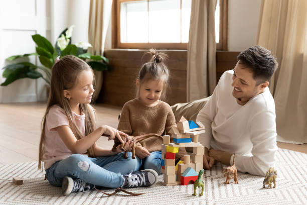istock Loving father play with cute little daughters at home 1209762765