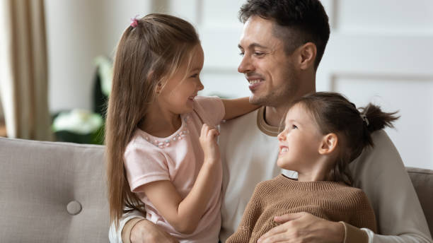 istock Loving dad play with little daughters at home 1209762800