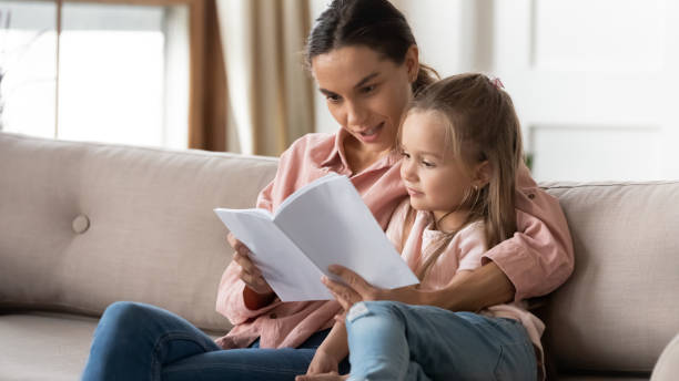istock Loving mum relax reading book with little daughter 1209762813