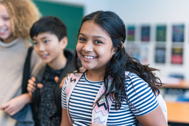 istock Confident elementary age girl with friends at school 1209763702