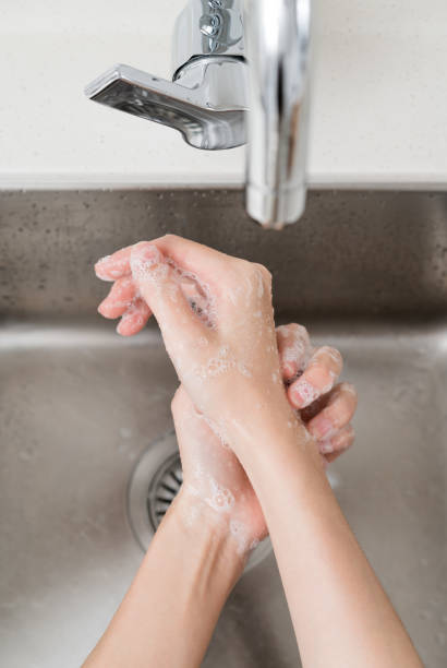 istock Asian woman washing hands  in a sink 1209763887