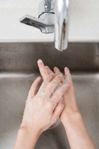 istock Asian woman washing hands  in a sink 1209763889