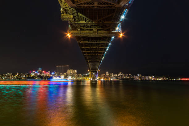 istock Modern cityscape at night background with bridge and water 1209764012