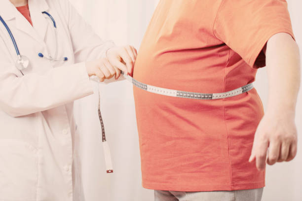 istock doctor measures  man measures  waist 1209764545