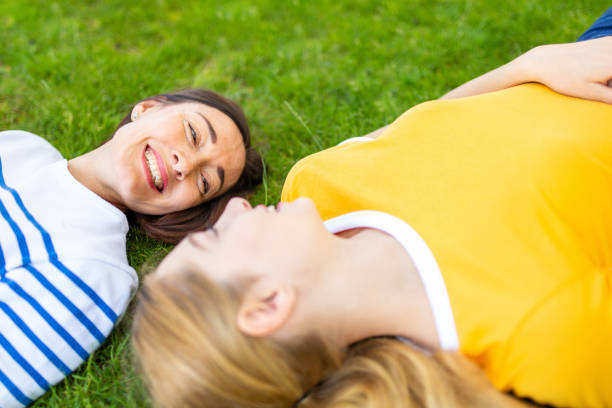 istock happy mother and daughter lying on grass outdoors together 1209764881