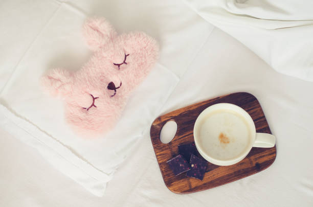 istock Cup of coffee with cute pink sleep mask 1209764981