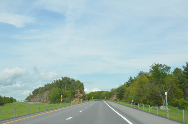 istock uphill road with trees and clouds and sky 1209769600