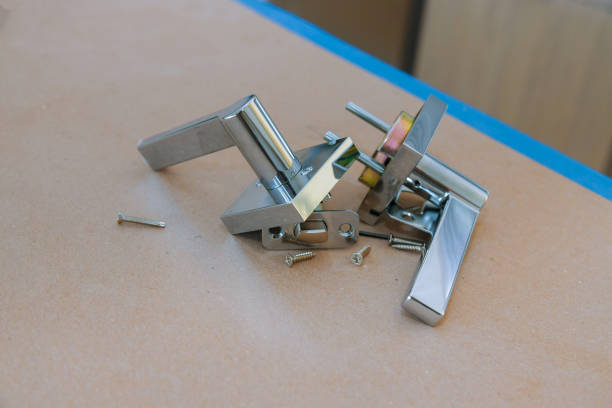 istock Assembling new doorknob the closeup of worker hands installing new door locker 1209774178