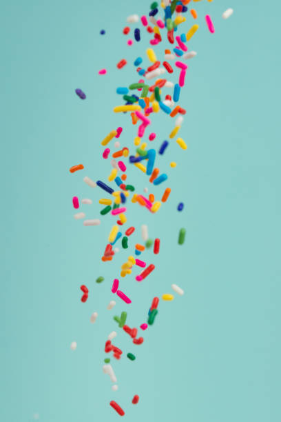 Falling pieces of colored caramel on a light background. Texture for design. Freezing in motion.