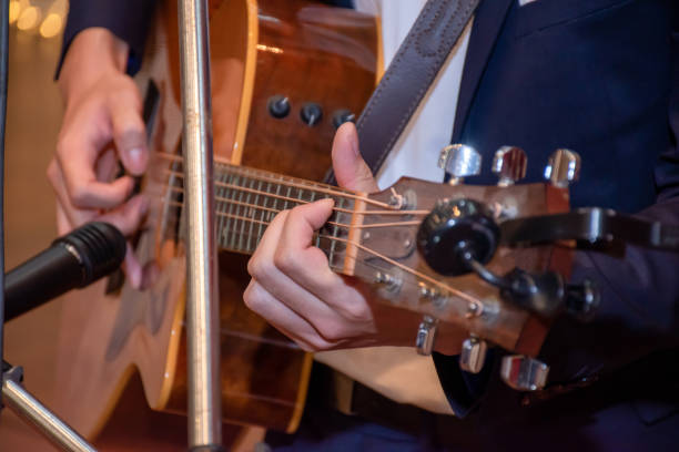istock Close-up on hand, A handsome young man plays the guitar for a live performance on stage. 1209774551