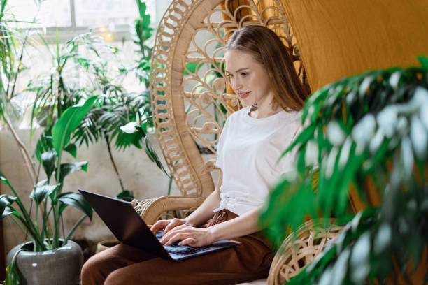 istock Young adult woman using modern laptop computer at home 1209777359