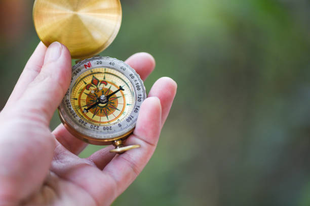 istock Man explorer searching direction with compass for map - Navigational compass travel and tourist concept 1209778943
