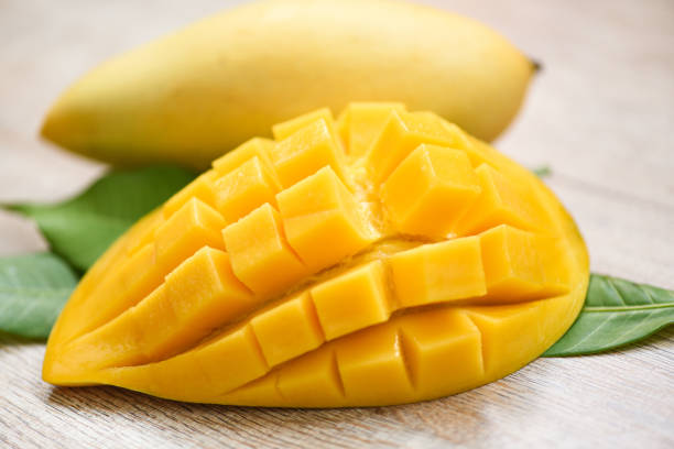 istock Mango slice and mango leaves from tree tropical summer fruit concept - Sweet ripe mangos cut half 1209779040