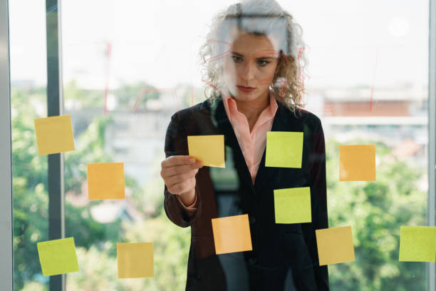 istock caucasian businesspeople with glass board and post it note having brainstorming in workplace 1209779778