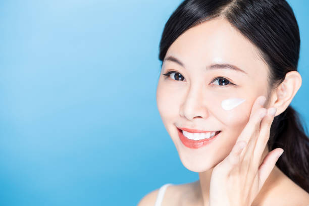 istock woman apply lotion on face 1209785583