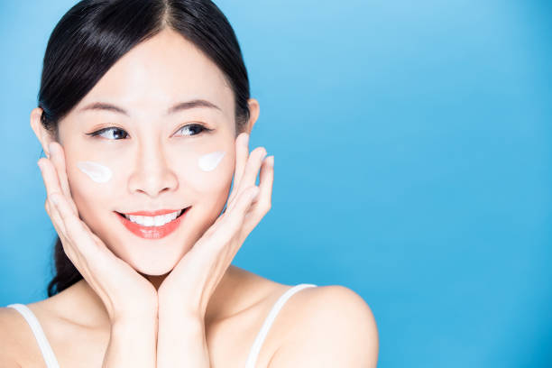 istock woman apply lotion on face 1209785585