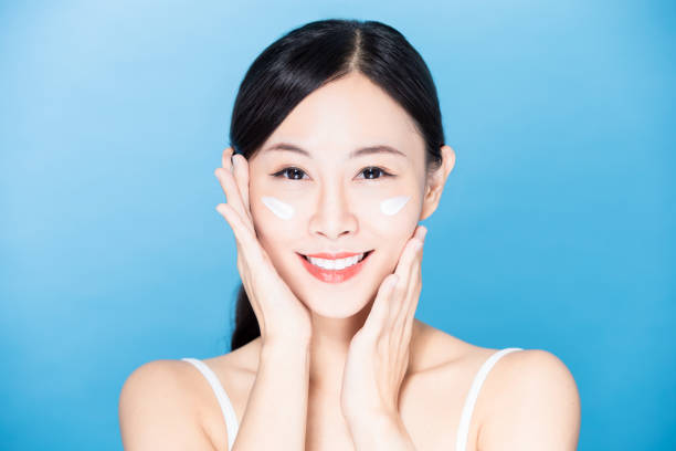 istock woman apply sunscreen on face 1209786657