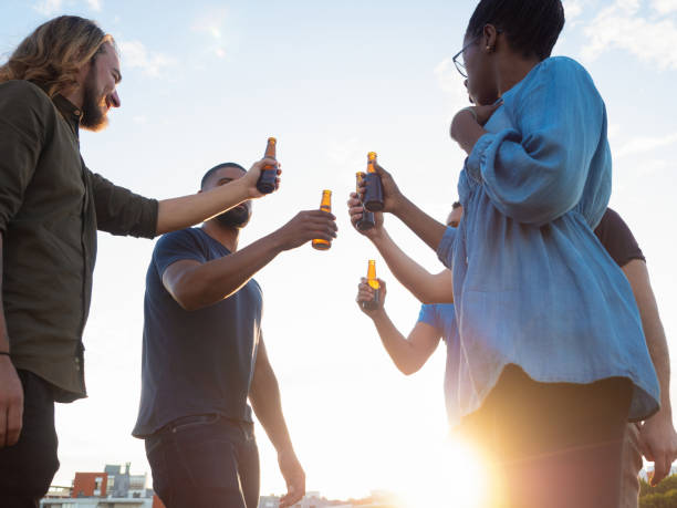 istock Bottom view of cheerful friends clinking beer bottles. 1209794226