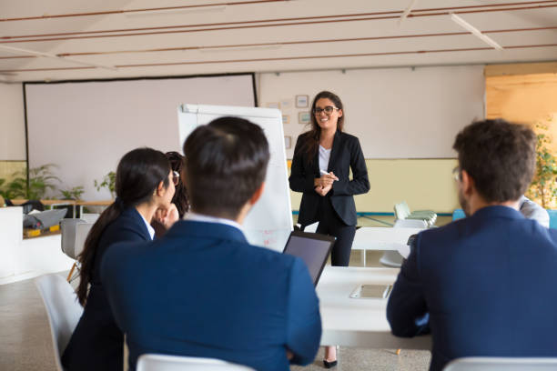istock Smiling female business trainer working with employees 1209794308