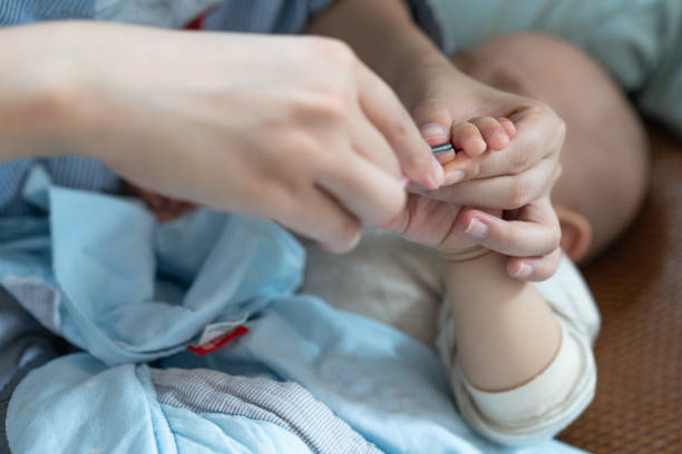 istock A mother cuts her nails for a sleeping child 1209804462