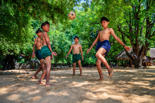 ragazzi birmani che giocano a chinlone nel villaggio vicino a bagan, myanmar - bagan myanmar burmese culture family foto e immagini stock