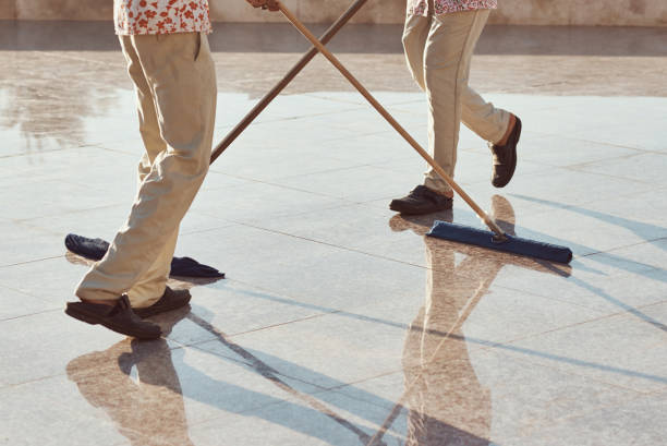 istock Two cleaners with mop cleaning marble floor outdoors. Cleaning service 1209807873