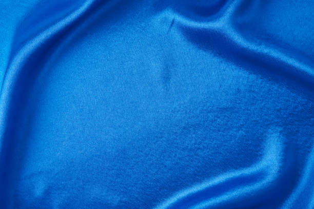 istock Blue silk background with a folds.  Abstract texture of rippled satin surface 1209807904