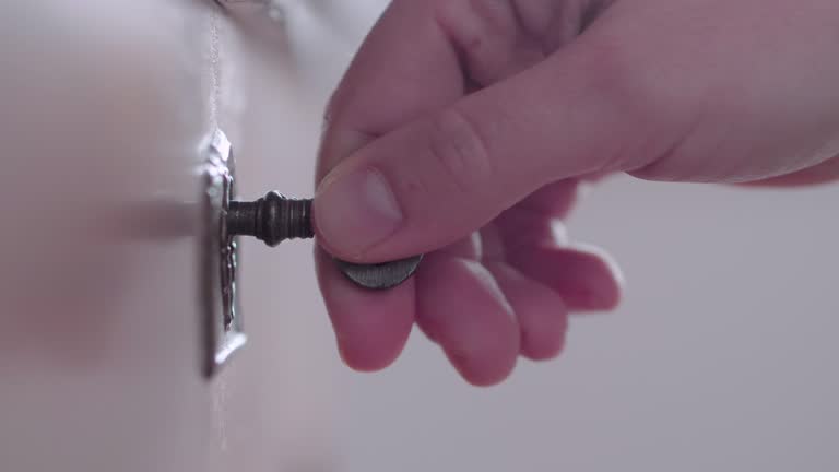 Extreme close up of a hand unlocking an ancient coffer with a key.