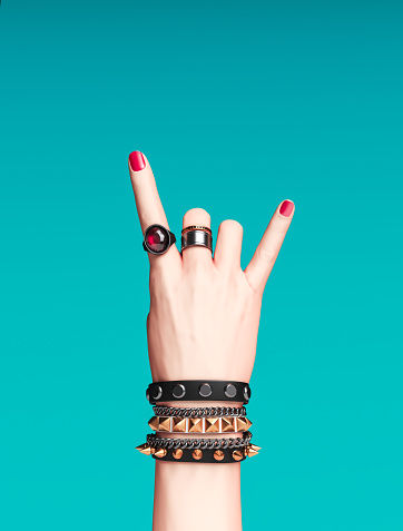 Rock hand sign, female hand punk rock gesture with gold wrist bracelets and finger rings isolated, creative art protest banner, fashion hipster accessories, 3d rendering