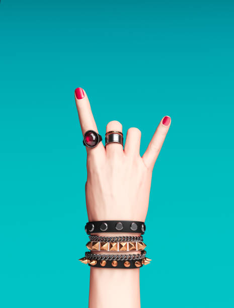 Rock hand sign, female hand punk rock gesture with gold wrist bracelets and finger rings isolated, creative art protest banner, fashion hipster accessories, 3d rendering Rock hand sign, female hand punk rock gesture with gold wrist bracelets and finger rings isolated, creative art protest banner, fashion hipster accessories, 3d rendering bracelet stock pictures, royalty-free photos & images