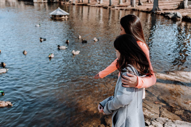 istock Sisters close to a lake feeding ducks 1209809153