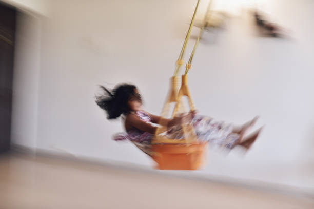 Happy senior couple having fun while riding on a chain swing at amusement park in blurred motion.