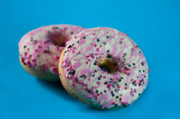 istock Pink donuts glazed stuffed with strawberry jam, blue background. 1209817216