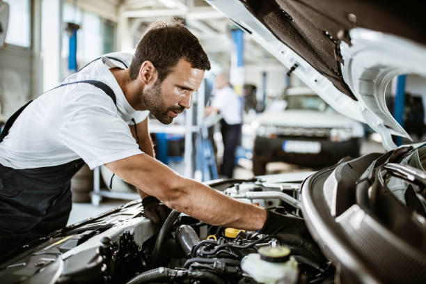 istock Young mechanic examining engine problems in auto repair shop. 1209822249