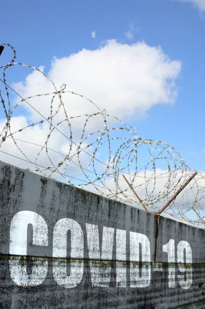 Concept of closing borders because virus covid-19 Concept of closing borders because virus covid-19, wall with barbwire and word covid-19 rusty barbed wire stock pictures, royalty-free photos & images