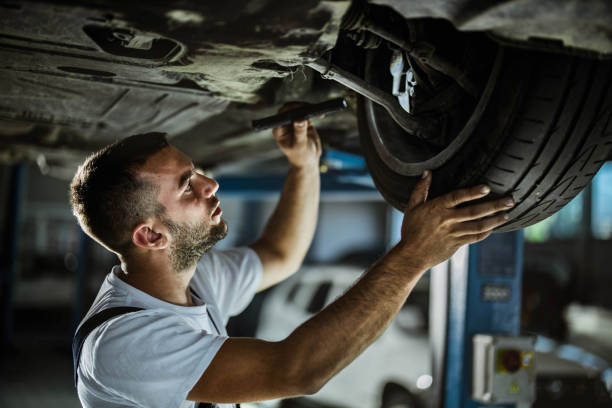 riparatore di auto che lavora su uno pneumatico in un'officina. - maintenance engineer car lamp protective workwear foto e immagini stock
