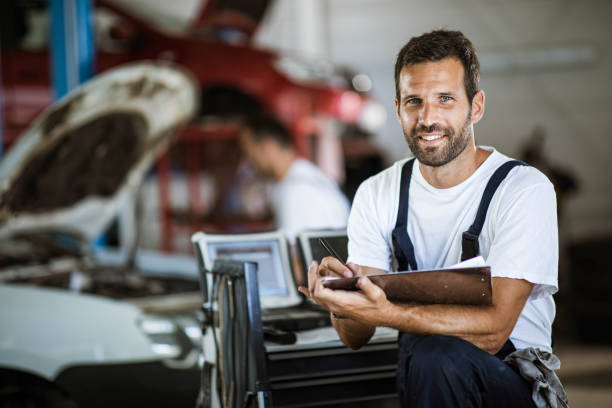 istock Happy mechanic going through checklist in auto repair shop. 1209823894