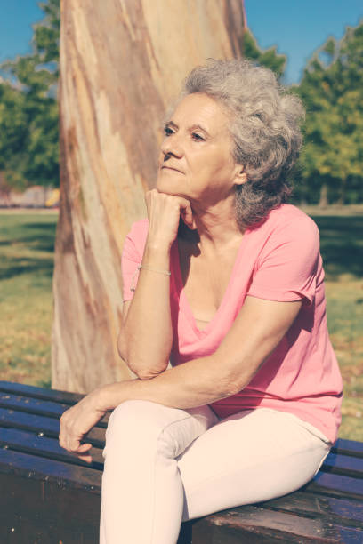 istock Pensive tired old lady waiting someone in park 1209827538