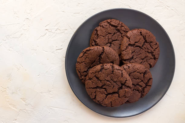 istock Top view, chocolate chip cookies on a black plate. white concrete background. From above. copy space 1209831882