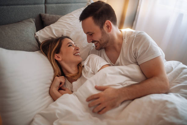 Happy couple sleeping in bed at home stock photo