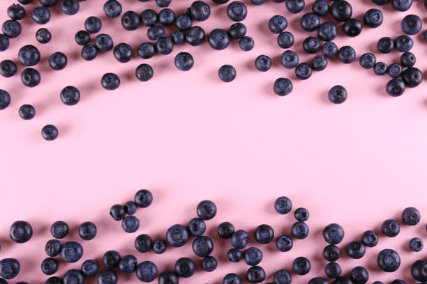 istock Beautiful fresh blueberries scattered on paper textured background. 1209834421