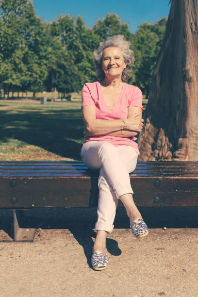 istock Happy confident old lady posing in park 1209834690