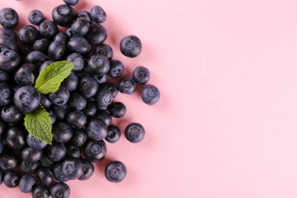 istock Beautiful fresh blueberries scattered on paper textured background. 1209834756