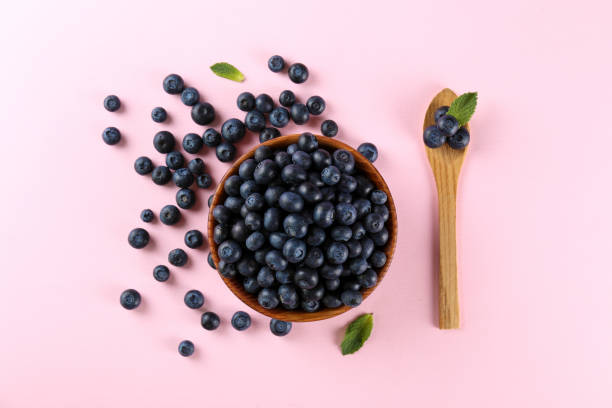 istock Beautiful fresh blueberries scattered on paper textured background. 1209834828